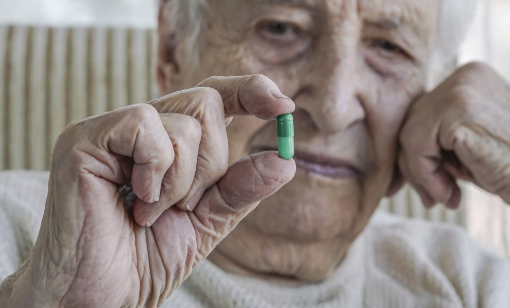 Elder Woman Holding Pill